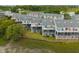 Aerial view of townhomes featuring balconies, backyard lawn space, and vibrant color schemes at 81 Sandbar Ln # 23, Folly Beach, SC 29439
