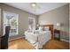 Cozy bedroom with a queen-sized bed, hardwood floors, and bright windows at 81 Sandbar Ln # 23, Folly Beach, SC 29439