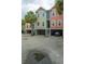 View of colorful condominiums with covered parking, palm trees, and well-maintained landscaping at 81 Sandbar Ln # 23, Folly Beach, SC 29439