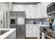 Bright kitchen featuring stainless steel appliances, white cabinets, and gray backsplash at 81 Sandbar Ln # 23, Folly Beach, SC 29439