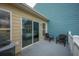 Relaxing outdoor patio with chairs, blue and tan siding and a sliding glass door at 81 Sandbar Ln # 23, Folly Beach, SC 29439