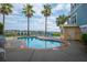 Community pool area with lounge chairs and a small structure and water views in the background at 81 Sandbar Ln # 23, Folly Beach, SC 29439