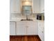 This kitchen showcases white cabinetry, stainless sink, and hardwood floors for a clean, modern appeal at 815 Harbor Pl Dr, Charleston, SC 29412