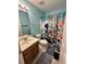 Quaint bathroom with a charming sailboat shower curtain, single sink vanity, and a matching ceramic toilet at 9122 Maple Grove Dr, Summerville, SC 29485