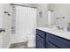 Modern bathroom featuring blue vanity, shower and tub with a white shower curtain at 101 Patterson Ave, Goose Creek, SC 29445