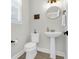 Well-lit powder room with a pedestal sink, a round mirror, and modern fixtures, providing a stylish and functional space at 101 Patterson Ave, Goose Creek, SC 29445