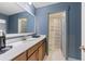 Stylish bathroom with a wood vanity, white countertop, and doorway to a tiled shower/tub combo at 1017 Saltwater Cir, Johns Island, SC 29455