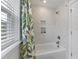 Bright white bathroom featuring shower and tub with leafy patterned shower curtain at 1017 Saltwater Cir, Johns Island, SC 29455