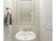 Modern bathroom with a pedestal sink, framed mirror, and towel ring against a neutral wall at 1017 Saltwater Cir, Johns Island, SC 29455
