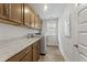 Well-equipped laundry room with abundant storage cabinets, marble countertops and modern washer and dryer at 1017 Saltwater Cir, Johns Island, SC 29455
