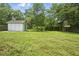 Backyard shed sits on a grass lawn with scattered mature trees at 102 Berkshire Ct, Goose Creek, SC 29445