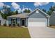 Charming single-story home with blue siding, well-manicured lawn, and a two-car garage at 122 Royal Cainhoy Way, Huger, SC 29450