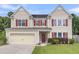 Charming two-story home featuring a two-car garage, red shutters, and a well-maintained lawn at 127 Rawlins Dr, Summerville, SC 29485