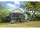 Backyard view of a home with a screened in porch and lush landscaping and mature trees at 1321 Wild Olive Dr, Mount Pleasant, SC 29464