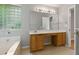 Bathroom with a glass-block window above a soaking tub, next to an oak vanity at 1321 Wild Olive Dr, Mount Pleasant, SC 29464
