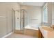 Bathroom with a glass enclosed shower, soaking tub with tile surround, and wood vanity at 1321 Wild Olive Dr, Mount Pleasant, SC 29464