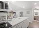 Modern kitchen island with a quartz countertop and stainless steel appliances, adjacent to a dining area and a doorway at 1326 Sea Elder Dr, Kiawah Island, SC 29455