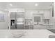 Bright kitchen with stainless steel appliances, white cabinets, a stylish backsplash, and quartz countertops at 1326 Sea Elder Dr, Kiawah Island, SC 29455