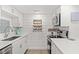 Well-appointed kitchen with white cabinets, stainless steel appliances, and charming coffee mug rack at 1326 Sea Elder Dr, Kiawah Island, SC 29455