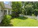 Spacious backyard featuring lush green grass, a white picket fence, and mature trees at 1431 Whispering Oak Trl, Mount Pleasant, SC 29466