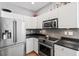 Bright, modern kitchen featuring stainless steel appliances, sleek gray backsplash, and white cabinets at 1431 Whispering Oak Trl, Mount Pleasant, SC 29466