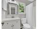 Bright bathroom with a white vanity, toilet, and shower/tub with a white curtain at 1433 Oaklanding Rd, Mount Pleasant, SC 29464
