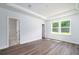 Serene bedroom showcasing tray ceilings, wood-look flooring, and sun-filled windows at 153 Royal Cainhoy Way, Huger, SC 29450