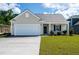 Charming single-Gathering home showcasing a two-car garage and a well-maintained front lawn and traditional design at 153 Royal Cainhoy Way, Huger, SC 29450