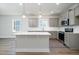 Bright kitchen with gray cabinetry, stainless steel appliances, large island, and modern pendant lighting at 153 Royal Cainhoy Way, Huger, SC 29450
