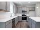 Modern kitchen with gray cabinets, stainless steel appliances, an island and white countertop at 153 Royal Cainhoy Way, Huger, SC 29450