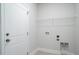 Functional laundry room features a white door, wire shelf, and utility connections for appliances at 153 Royal Cainhoy Way, Huger, SC 29450