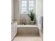 Bright bathroom featuring a soaking tub, white cabinets, and neutral tile work at 1532 Sea Palms Cres, Mount Pleasant, SC 29464
