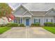 Charming gray home with blue shutters and a well-manicured front yard creates a welcoming curb appeal at 159 Townsend Way, Summerville, SC 29483
