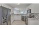 Bright kitchen featuring white cabinets, black appliances, and stylish herringbone backsplash at 159 Townsend Way, Summerville, SC 29483