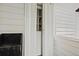 Bright white front door with sidelight providing natural light, complemented by white siding and a rustic bench at 1604 Jungle Rd, Edisto Island, SC 29438