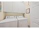 Functional laundry room with white washer, dryer, and overhead cabinets at 1604 Jungle Rd, Edisto Island, SC 29438