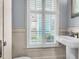 Bright bathroom with beadboard, pedestal sink, and plantation shutters at 183 Ionsborough St, Mount Pleasant, SC 29464