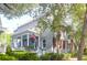 Charming two-story home with a classic front porch, an American flag, and mature trees at 183 Ionsborough St, Mount Pleasant, SC 29464