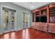 Living room featuring hardwood floors, built-in entertainment center, and access to the balcony at 183 Ionsborough St, Mount Pleasant, SC 29464