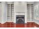 Traditional living room features a fireplace, built-in shelving, hardwood floors, and plantation shutters at 183 Ionsborough St, Mount Pleasant, SC 29464