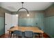 Dining room with a large wooden table, blue chairs, eye-catching wallpaper, and wainscoting at 1940 Orangeburg St, North Charleston, SC 29405
