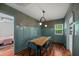 Dining room with a large wooden table, blue chairs, eye-catching wallpaper, and wainscoting at 1940 Orangeburg St, North Charleston, SC 29405