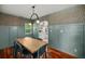 Dining room with a large wooden table, blue chairs, eye-catching wallpaper, and wainscoting at 1940 Orangeburg St, North Charleston, SC 29405