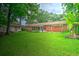 Expansive backyard featuring well-maintained lawn, storage shed, banana trees, pergola, and brick home at 1967 Campion Hall Rd, Charleston, SC 29407