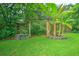 Lush backyard with mature trees, banana trees, and a unique wooden feature, offering a private and serene outdoor space at 1967 Campion Hall Rd, Charleston, SC 29407