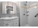 Well-lit bathroom with white vanity, framed mirror, and a shower featuring white tiles and grab bars at 1967 Campion Hall Rd, Charleston, SC 29407