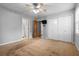 Spacious bedroom with neutral carpet, a ceiling fan, and large closet doors, leading to a view of the en suite at 1967 Campion Hall Rd, Charleston, SC 29407
