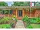 Beautiful brick home with a charming front porch, well-maintained lawn, and landscaped garden, offering a welcoming curb appeal at 1967 Campion Hall Rd, Charleston, SC 29407