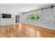 Bright living room with hardwood floors, decorative barn-door shutters, and a wood paneled accent wall at 1967 Campion Hall Rd, Charleston, SC 29407
