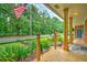 Covered front porch featuring wood columns, decorative plants, and a view of the tree-lined street at 1967 Campion Hall Rd, Charleston, SC 29407